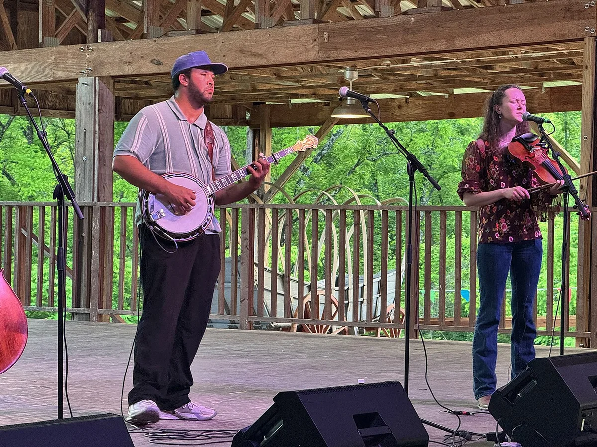Tray Wellington playing banjo with his band on an outdoor stage