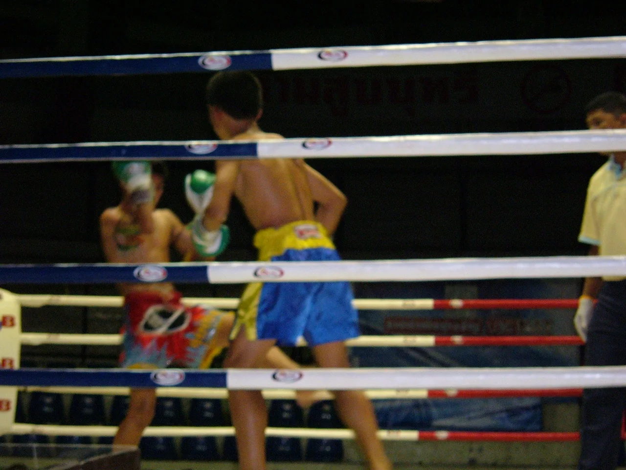 Two Muay Thai boxers competing in the ring at Rajadamnern Stadium in Bangkok