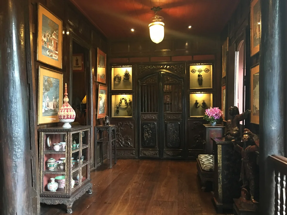 Wooden living room and display cabinets inside the Jim Thompson House Museum