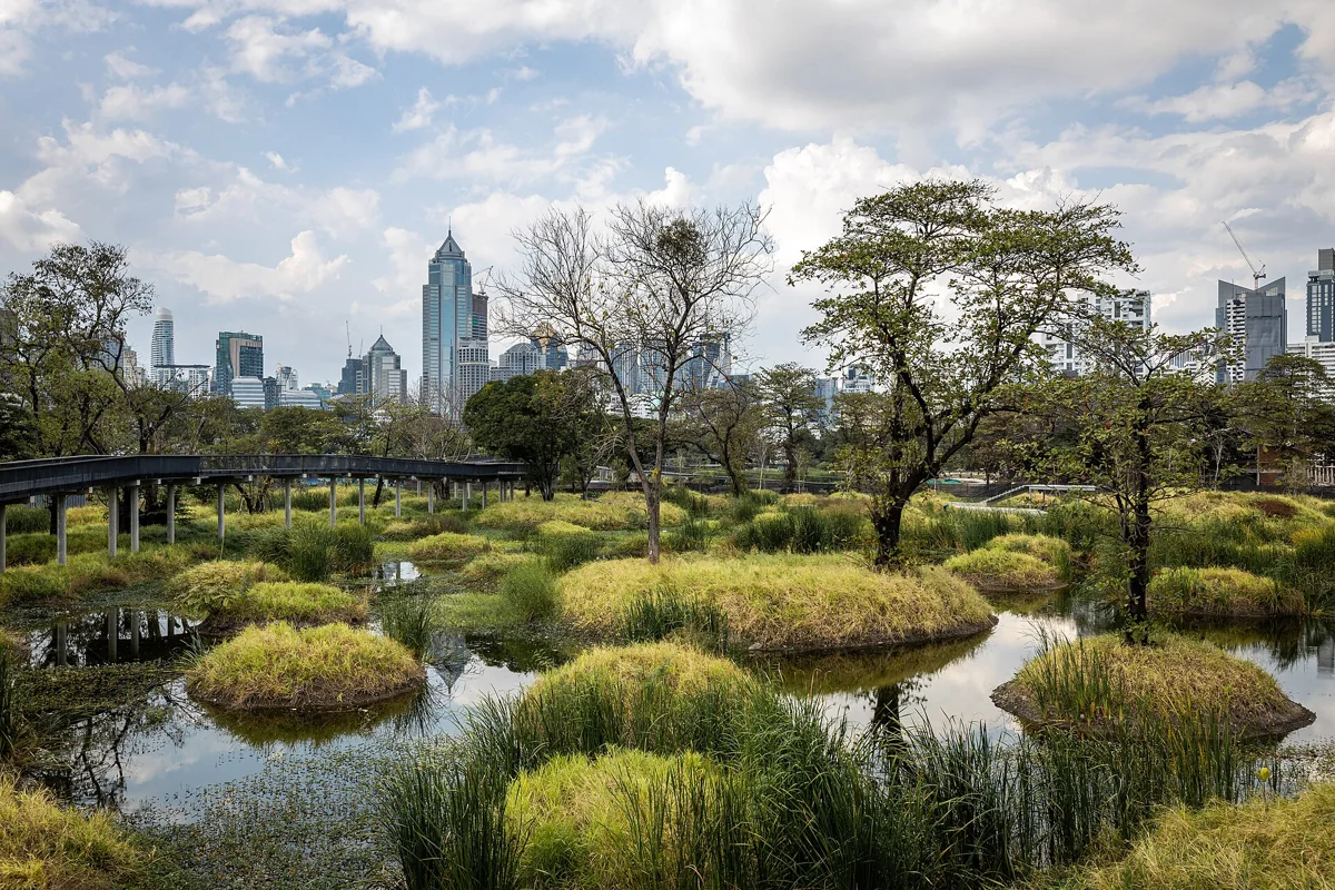 Wetlands and elevated paths at Benjakitti Forest Park with Bangkok buildings behind